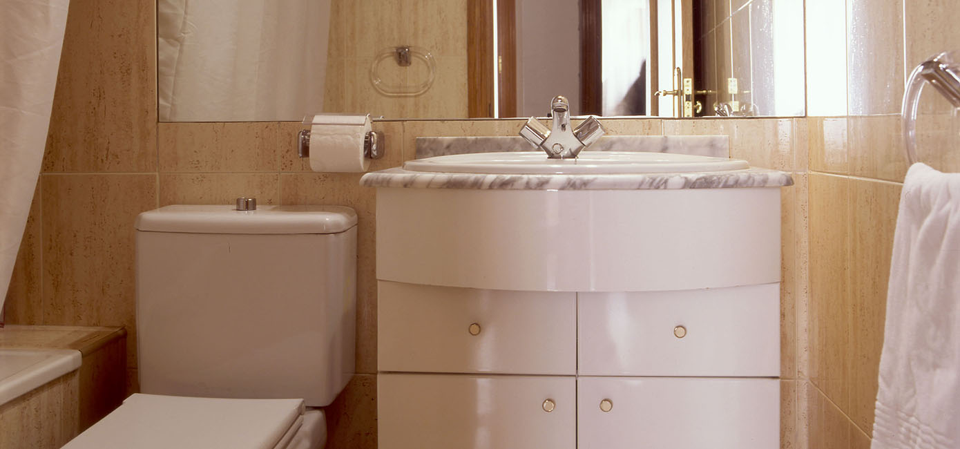 Baño completo con gran espejo y bañera, paredes revestidas en mármol y con todos los accesorios