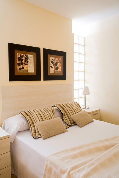 Primer plano del dormitorio con cama de matrimonio del apartamento del Edificio Proinca Los Molinos en Tetuán