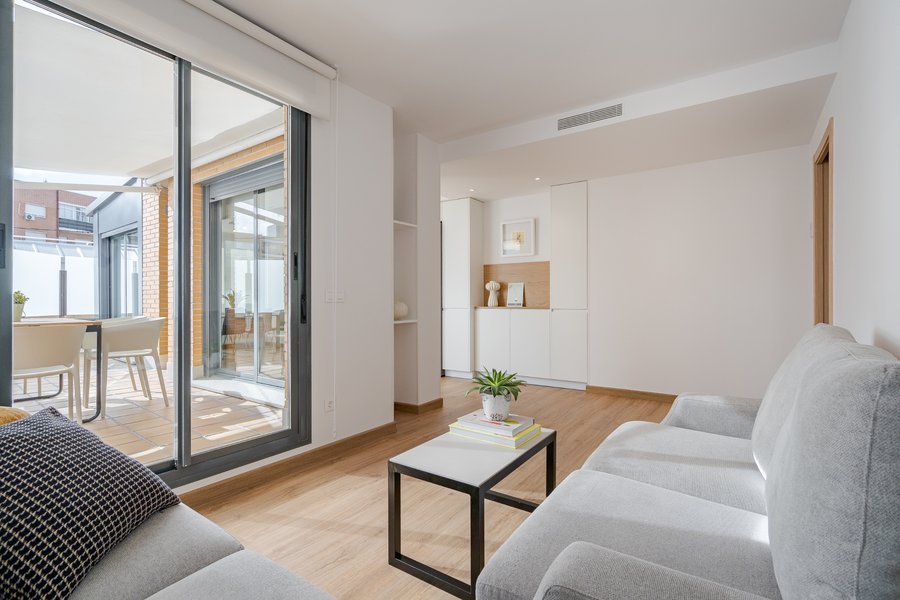Sala de estar con acceso a terraza exterior en piso amueblado de 3 habitaciones en alquiler en la calle Los Molinos 1, barrio de Tetuán, Madrid.
